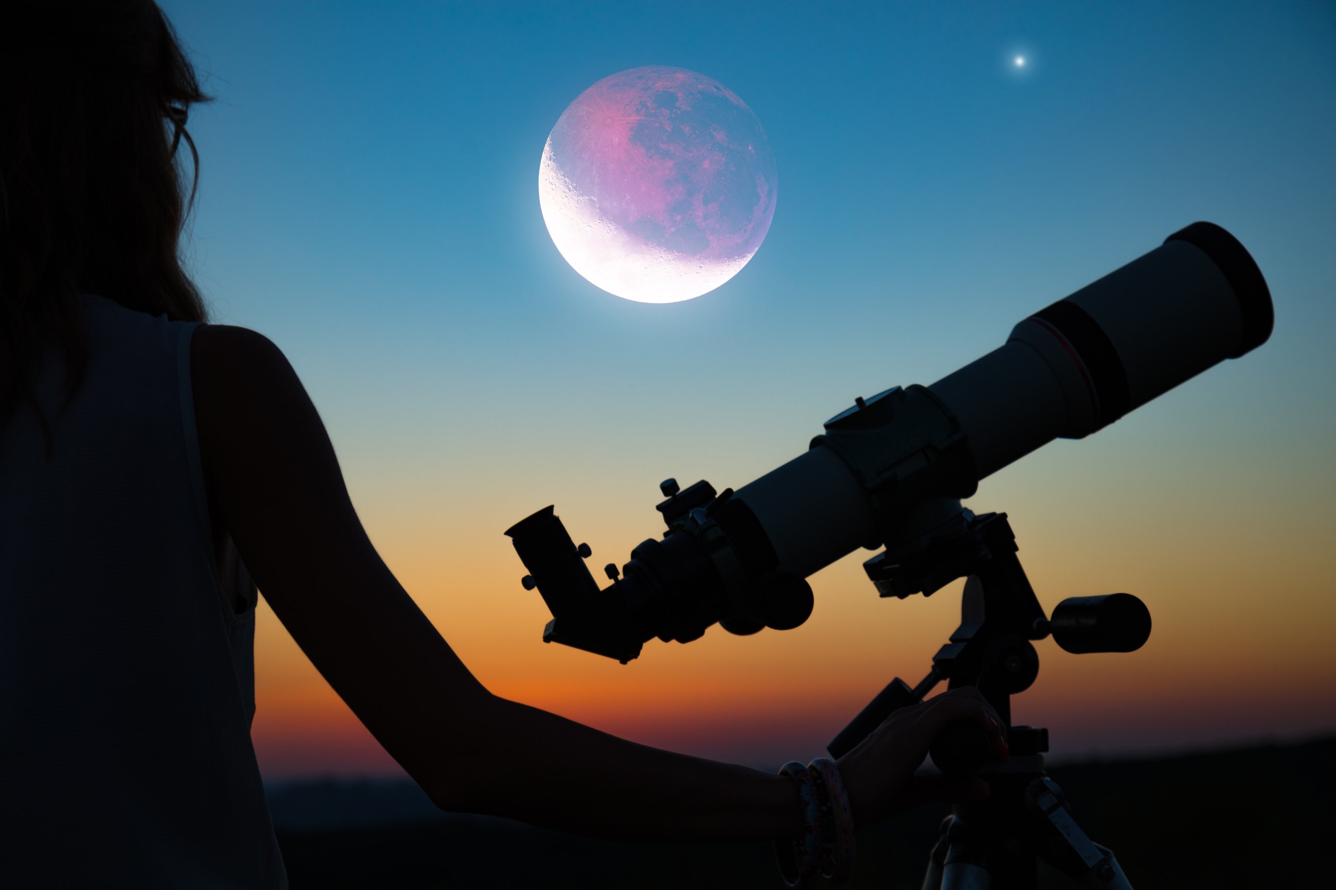 Girl looking at lunar eclipse through a telescope. My astronomy work.